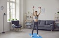 Girl doing sports workout with dumbbels at home