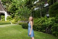 Young girl standing on green grass near resort house. Royalty Free Stock Photo