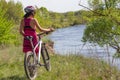 Young girl standing near bike in the sports shock-helmet. Summer tourism