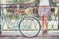 Young girl standing near fence near vintage bike at park Royalty Free Stock Photo