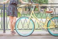 Young girl standing near fence near vintage bike at park Royalty Free Stock Photo