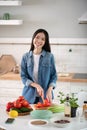 Young girl standing near the kitchen table slicing peppers. Royalty Free Stock Photo