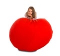 Young girl standing near round shape red beanbag chair Royalty Free Stock Photo