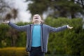 Girl standing in the park with arms wide open Royalty Free Stock Photo