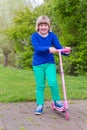 Young girl standing with pink scooter Royalty Free Stock Photo