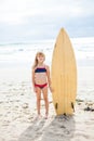 Young girl standing with surfboard on beach Royalty Free Stock Photo