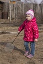 Young girl standing with tennis racket in the yard.