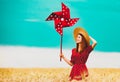 Girl is standing on a wheat field with pinwheel Royalty Free Stock Photo