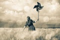 Girl is standing on a wheat field with pinwheel Royalty Free Stock Photo