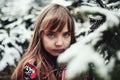 Young girl standing in a wintery landscape and gazing directly at the camera