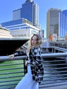 A young girl stands against the background of Canada Place against the backdrop of a cruise liner The skyscrapers of Royalty Free Stock Photo