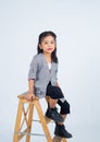 small girl sitting on top of ladder wearing a blazer