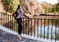 Young girl stands on the bridge in the park in autumn Royalty Free Stock Photo