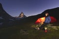 Young girl stands near her tent with the Matterhorn 4478m peak in background.
