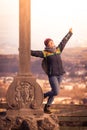 Young girl stands proud and happy on a summit cross, autumn