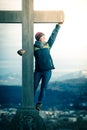 Young girl stands proud and happy on a summit cross, autumn