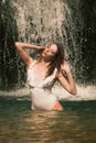 A young girl stands waist-deep in the lake, with both hands fixing her wet hair Royalty Free Stock Photo