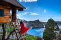 Young girl on steps of house on tree at Atuh beach in Nusa Penida island, Bali in Indonesia.