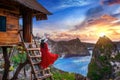 Young girl on steps of house on tree at sunrise in Nusa Penida island, Bali in Indonesia Royalty Free Stock Photo