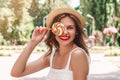 Young girl in a straw hat and a multi-colored lollipop walks in the park Royalty Free Stock Photo