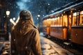 A young girl on the street in winter looks sadly at a tram moving away from her. The concept of farewell, separation