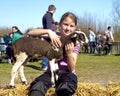 A young girl stroking a new born lamb Royalty Free Stock Photo