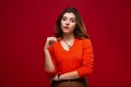 Young girl student or business woman girl in glasses with swith a pensive expression on a red background