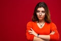 Young girl student or business woman girl in glasses with swith a pensive expression on a red background