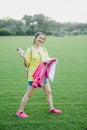 Young girl student having fun on grass field in the afternoon in campus