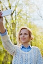 Young girl student having fun and taking selfie photo on smartphone camera outdoor in green park in sunny day, teenage trand Royalty Free Stock Photo