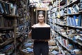 Girl student sitting in a library with a laptop and learning lessons, a woman using a computer in a bookstore, technology concept Royalty Free Stock Photo