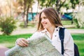 A young girl student walks around the city with a map and looking for a way. Exchange students concept