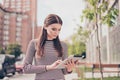 Young girl is studying in the spring park outside, browsing on h Royalty Free Stock Photo