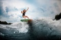 Young girl stunting on a wakeboard in the river near forest Royalty Free Stock Photo