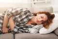 Young girl suffering from stomachache lying down on sofa Royalty Free Stock Photo