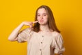 Young girl in summer dress shows Italian sign tasty, pressing a finger to the cheek. Language of the body