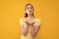 young girl in summer striped tshirt on yellow background. blow kiss