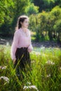 Young girl on a summer sunny day walking in field of flowers Royalty Free Stock Photo