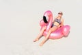 Young girl sunbathing on pink flamingo on a sandy beach Royalty Free Stock Photo