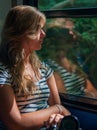 Young girl in sunset lighting traveling in train car and her reflection in window Royalty Free Stock Photo