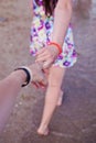 Young girl supporting man, holding hand on the beach