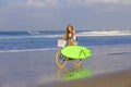 Young girl with surfboard and bicycle Royalty Free Stock Photo