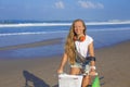 Young girl with surfboard and bicycle Royalty Free Stock Photo