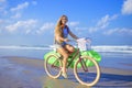 Young girl with surfboard and bicycle Royalty Free Stock Photo