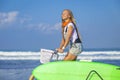 Young girl with surfboard and bicycle Royalty Free Stock Photo