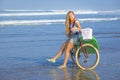 Young girl with surfboard and bicycle Royalty Free Stock Photo