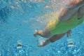 Young girl swimmer swimming freestyle in pool, under water view, sport and fitness