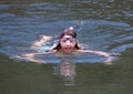 Young girl swimming with goggles and snorkel