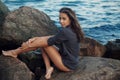 Young girl in a swimsuit on the rocks near sea Royalty Free Stock Photo