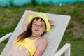 Young girl in a swimsuit on a shelf by the pool